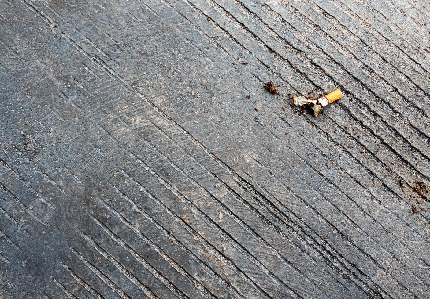 The cigarette butt let down on the concrete floor photo