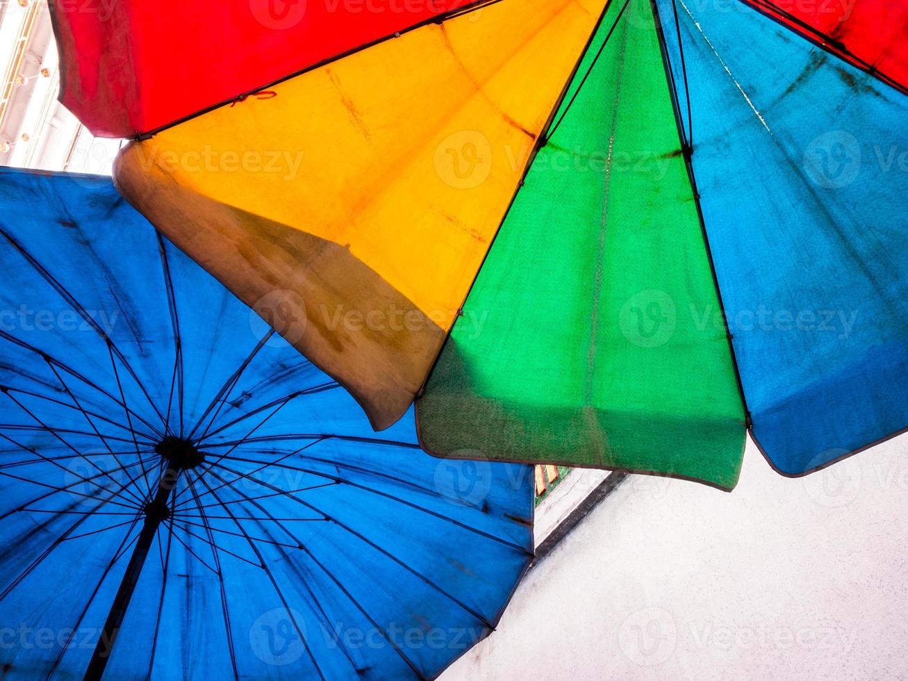 vívidos multicolores en la vieja y sucia sombrilla de playa foto