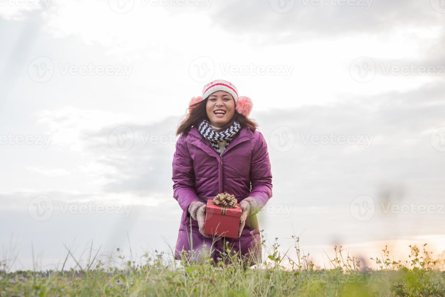 Happy young woman with gift in hands. Christmas and winter concept. photo