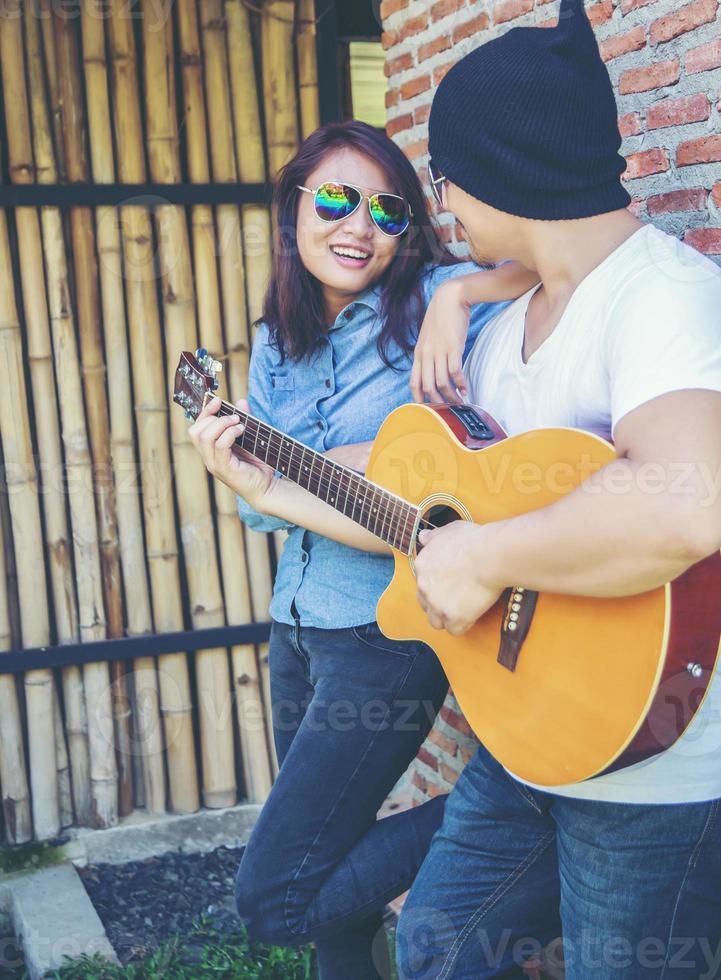 Young hipster man playing guitar to relaxing on his holiday, enjoy with natural and fresh air. photo