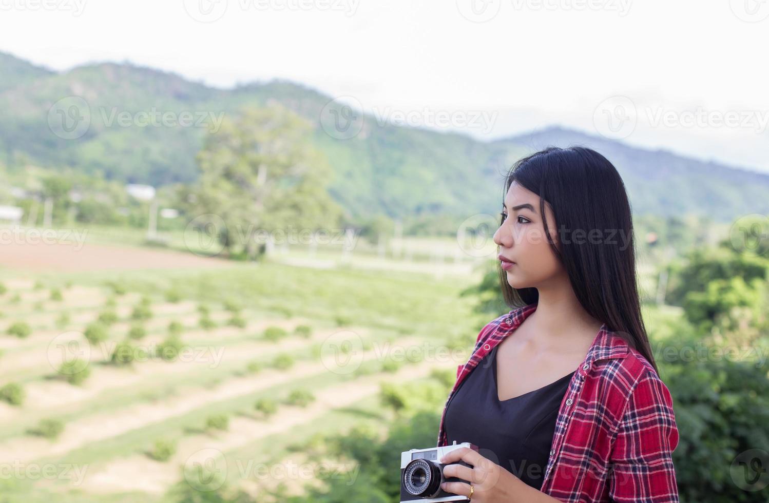 vintage de fotografía de mujeres hermosas mano de pie sosteniendo cámara retro con amanecer, estilo suave de ensueño foto