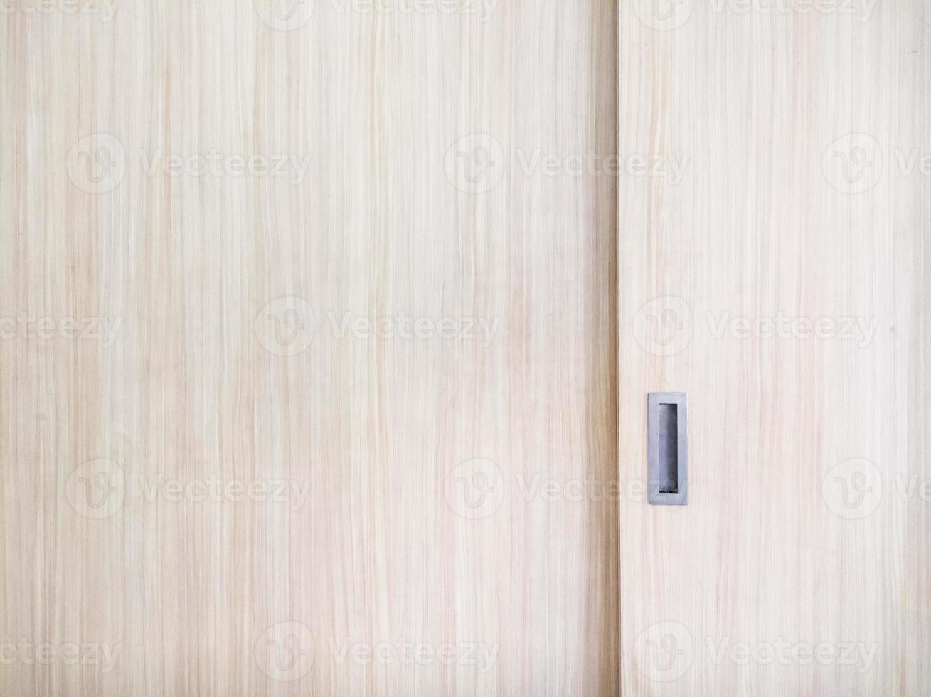 Puerta corredera de armario de madera con mango de metal. foto