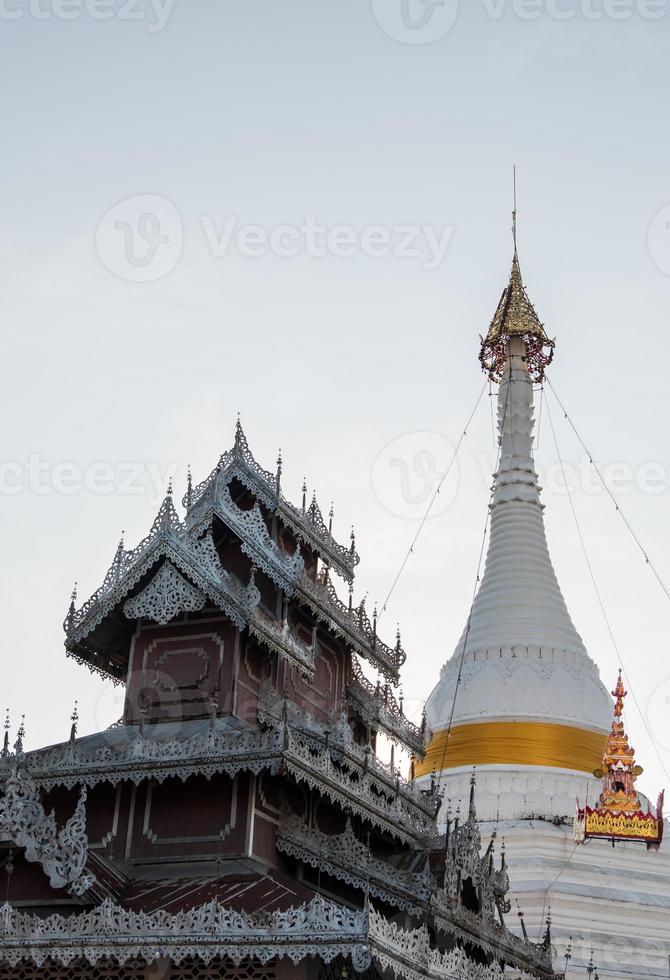 White pagoda and the old church with the metal stencil in the traditional Myanmar style. photo