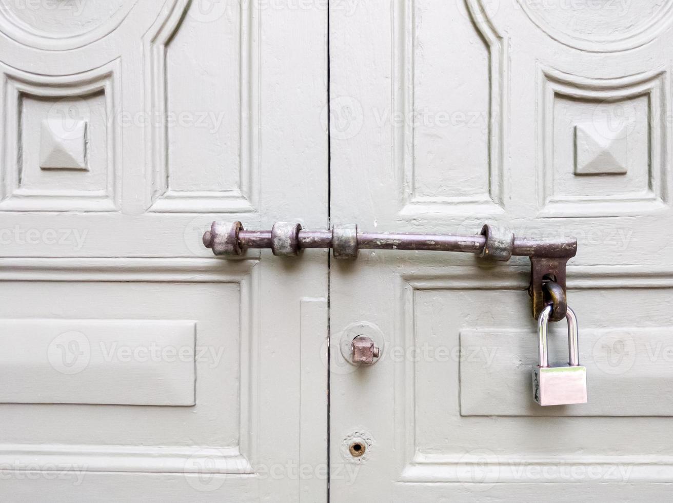 Old wooden gate with the new metal padlock. photo