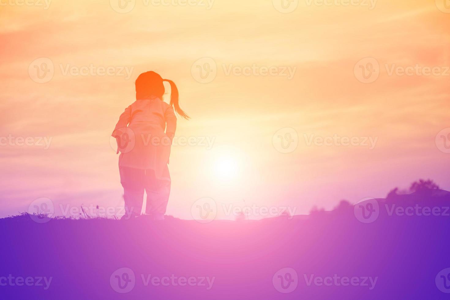 silueta de niño, momentos de alegría del niño. en la puesta de sol de la naturaleza foto