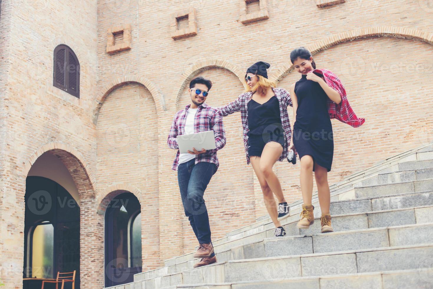 Summer holidays and hipster teenagers group traveling together in urban town having fun and happy time together. photo