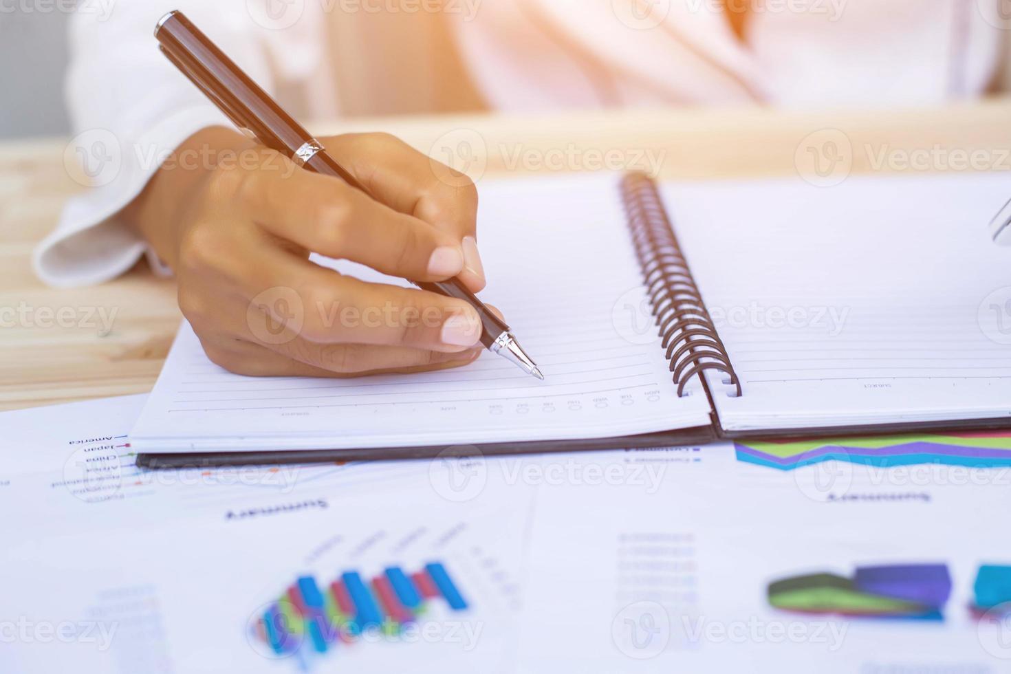 Hands of Businessman working on Laptop Computer with Data Charts photo