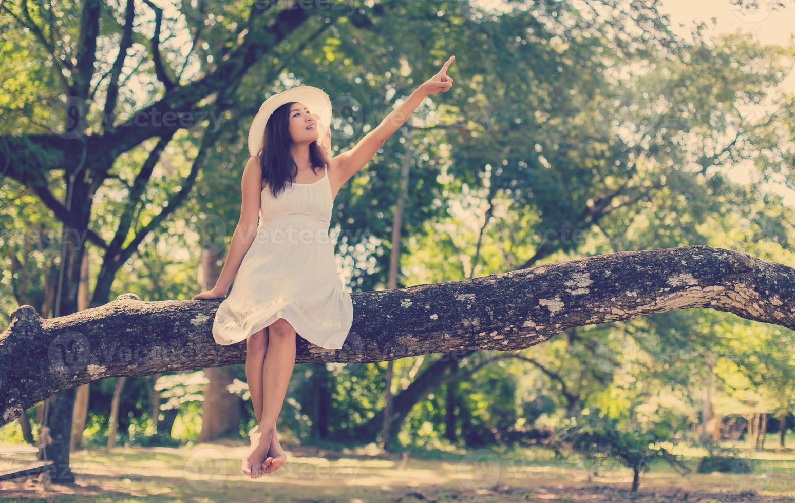 Young teen girl sitting on tree photo