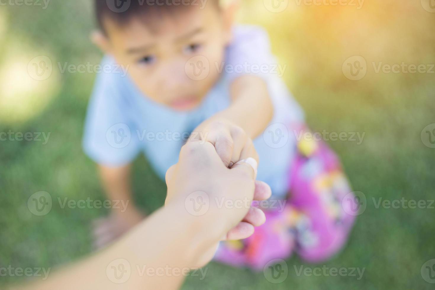 Happy boy child is smiling enjoying adopted life. Portrait of young boy in nature, park or outdoors. Concept of happy family or successful adoption or parenting. photo