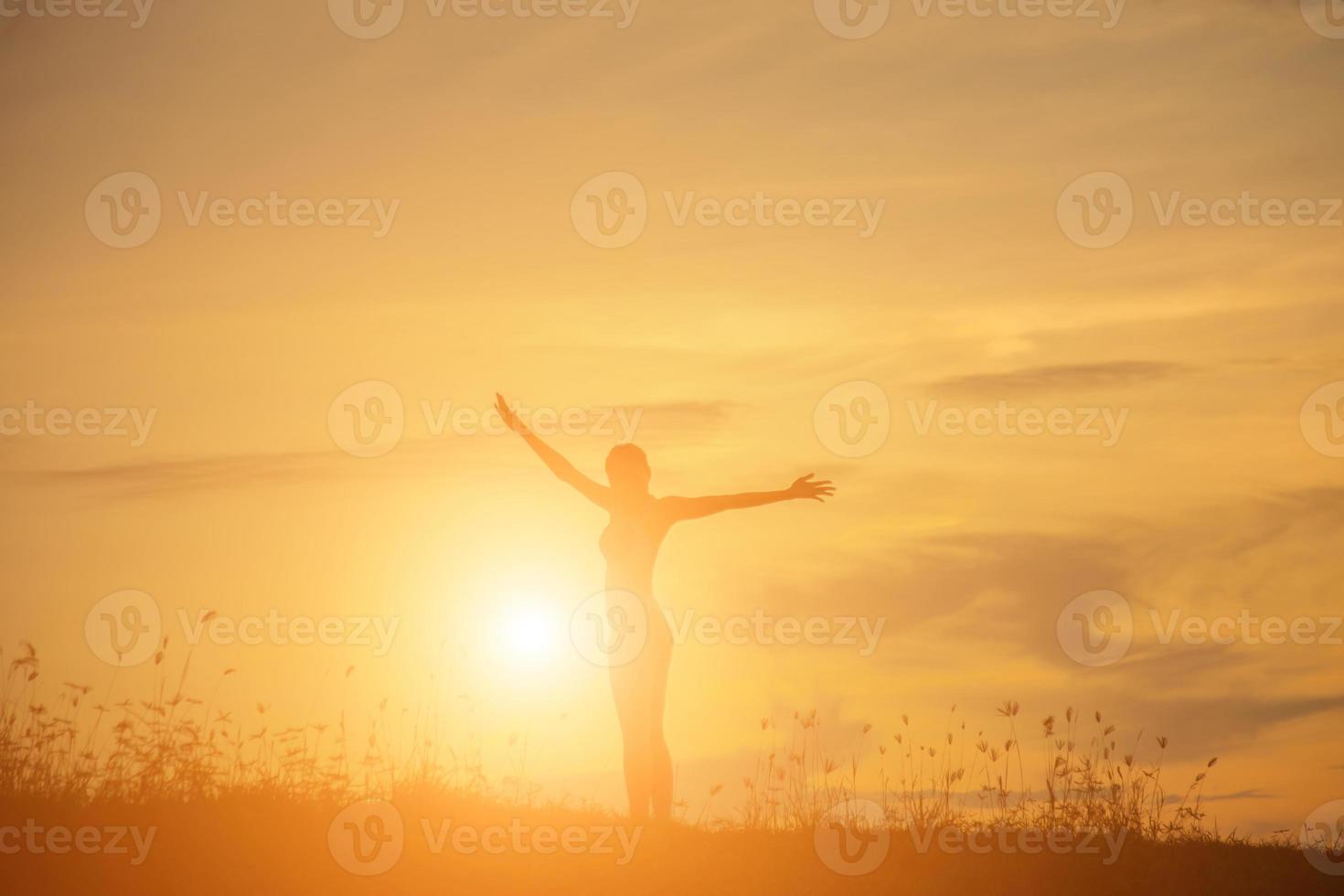 Silhouette of woman praying over beautiful sky background photo