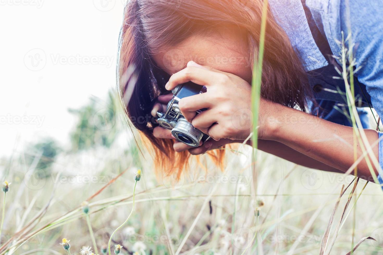 vintage de fotografía de mujeres hermosas mano de pie sosteniendo cámara retro con amanecer, estilo suave de ensueño foto