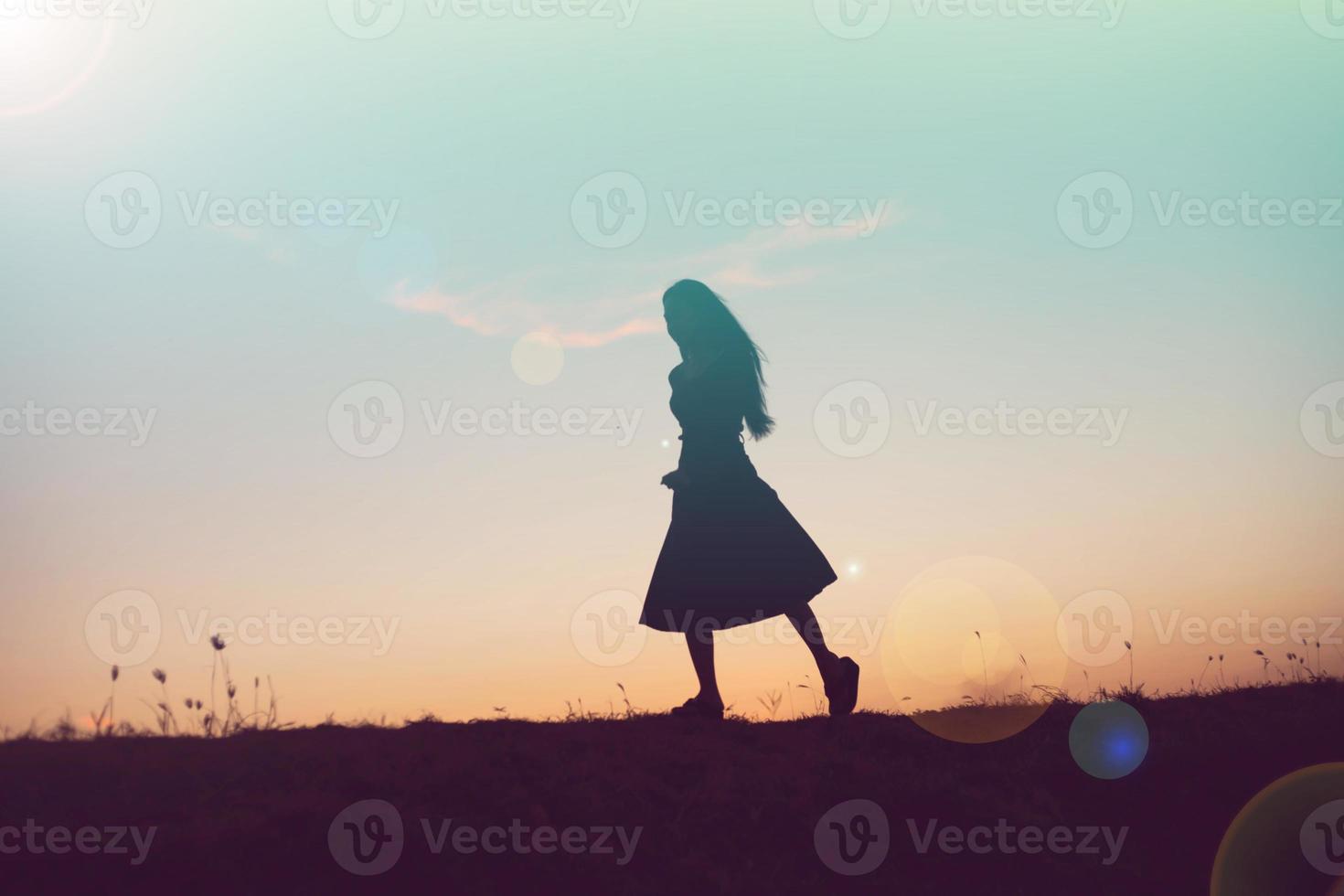 silhouette of a young woman standing alone photo