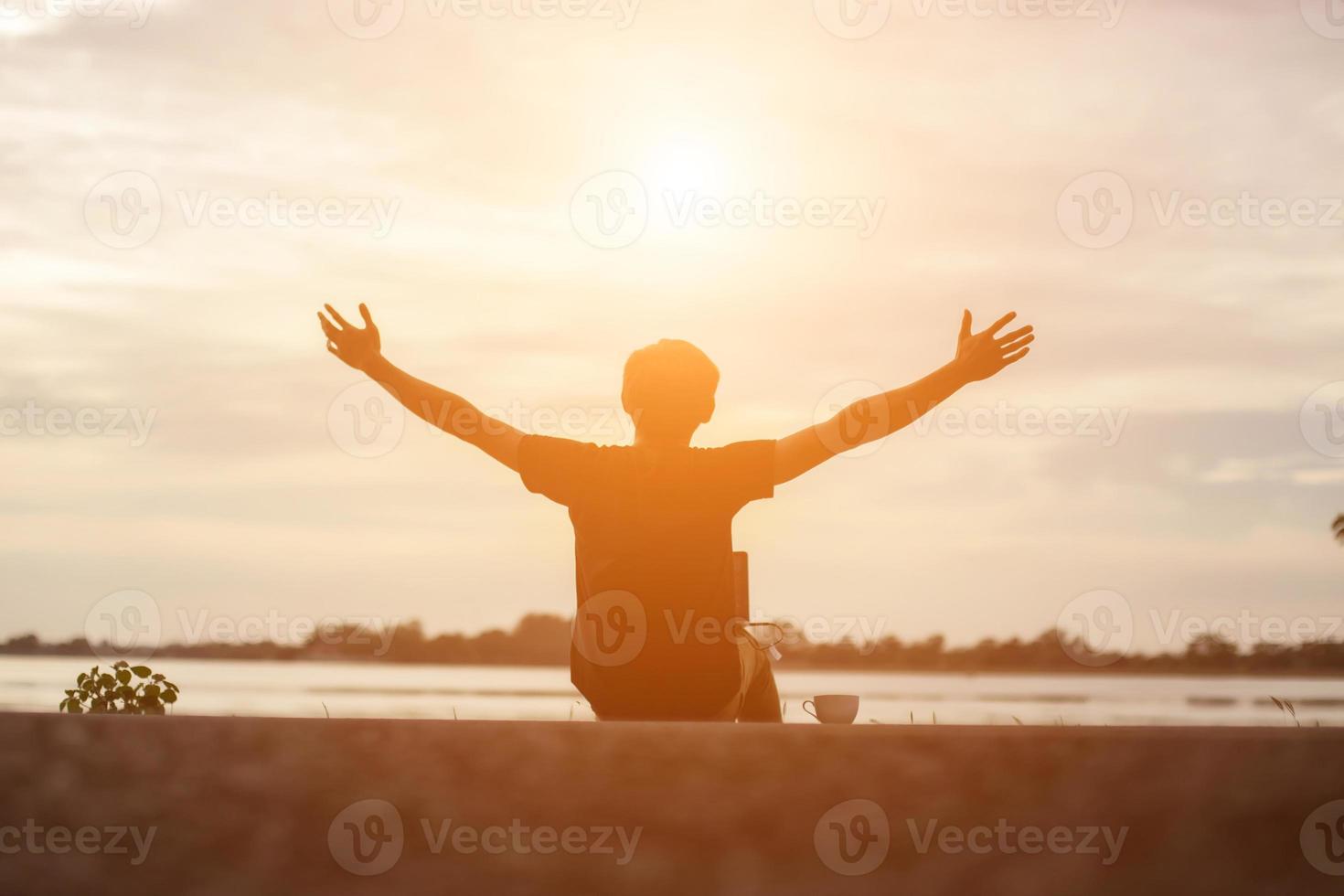 exitoso deportista levantando los brazos en el cielo dorado retroiluminación puesta de sol verano después de cruzar la carrera. atleta masculino de fitness con los brazos arriba celebrando goles después de hacer ejercicio deportivo y hacer ejercicio al aire libre. foto