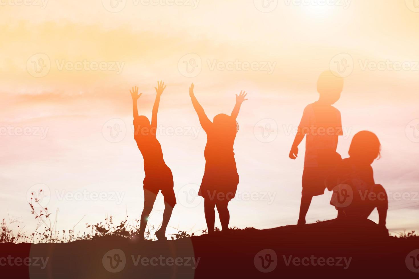 silueta de niños felices y puesta de sol feliz foto