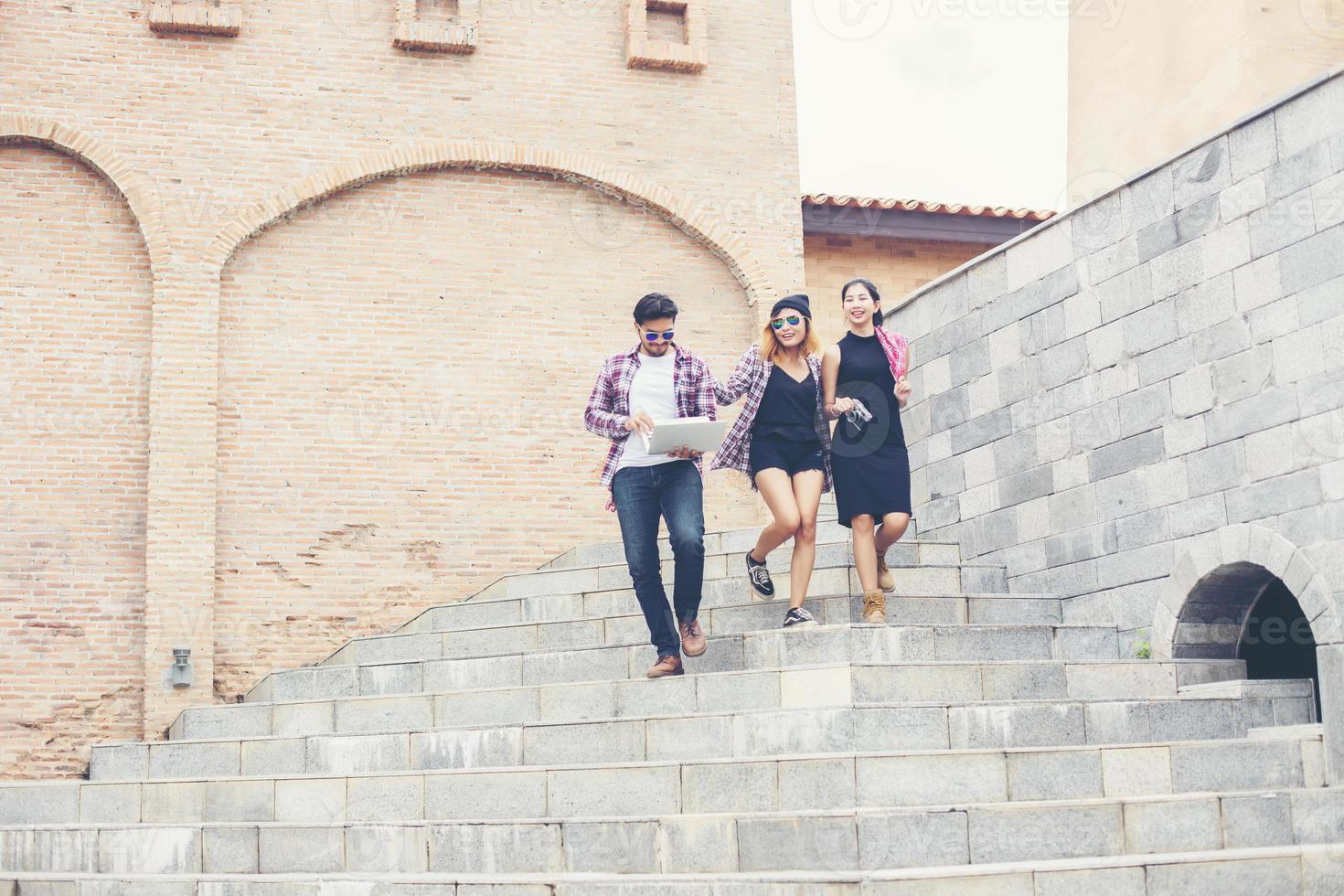 Summer holidays and hipster teenagers group traveling together in urban town having fun and happy time together. photo