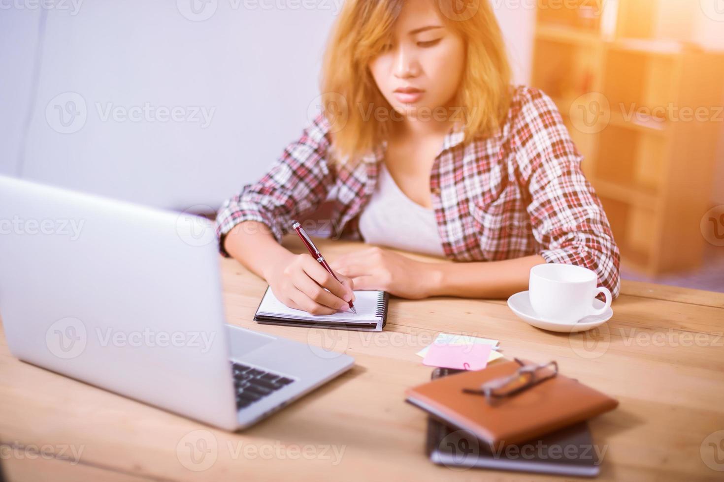 Business Woman Writing with pen in notepad on workplace. photo