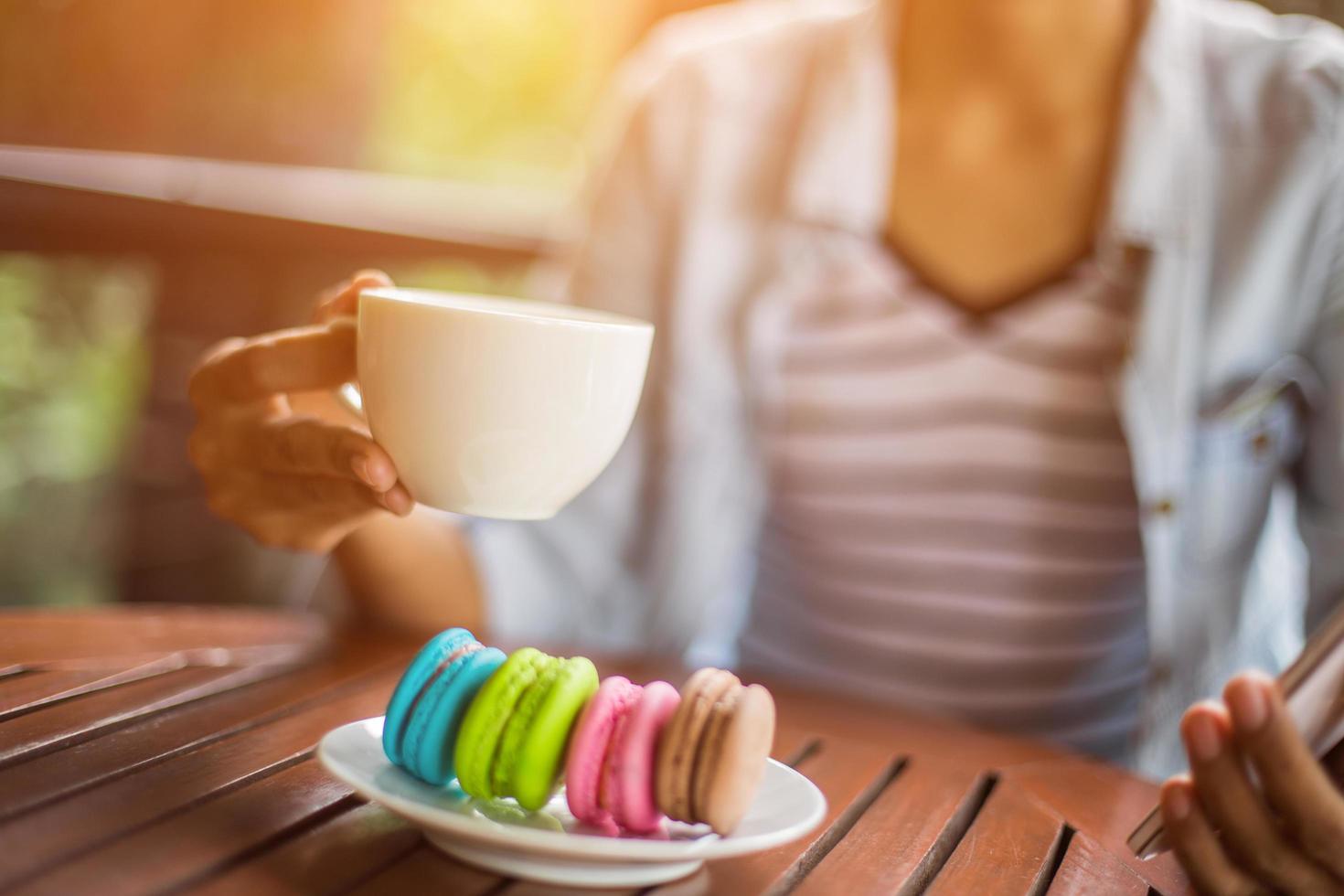 macarrones de san valentín con café en la mesa de madera. imagen tonificada foto