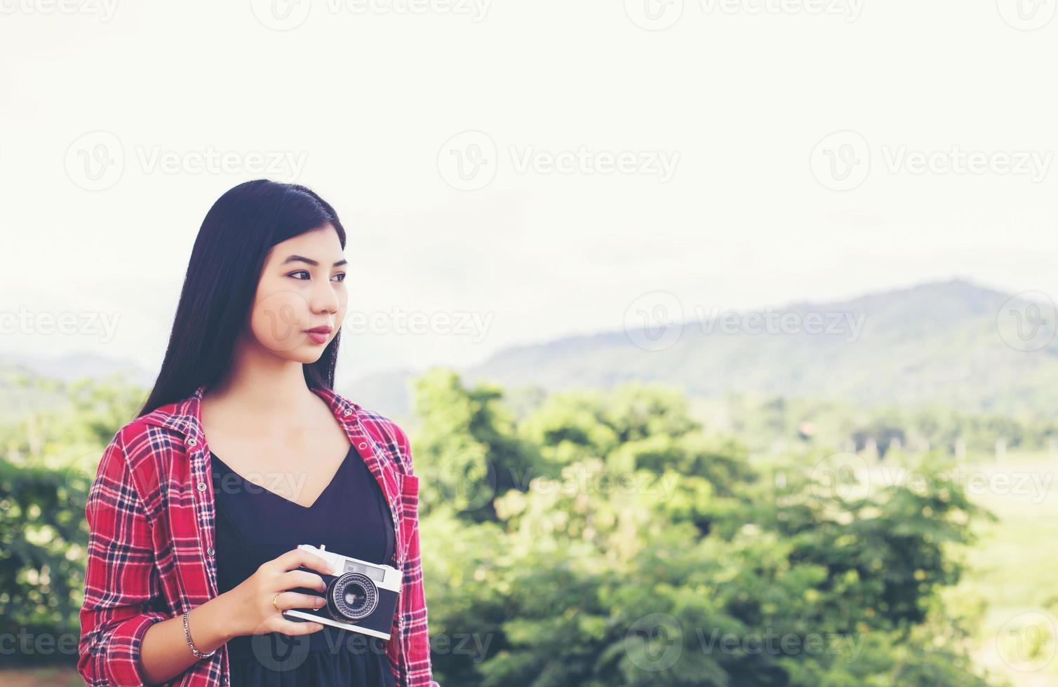 Vintage of beautiful women photography standing hand holding retro camera with sunrise,dream soft style photo