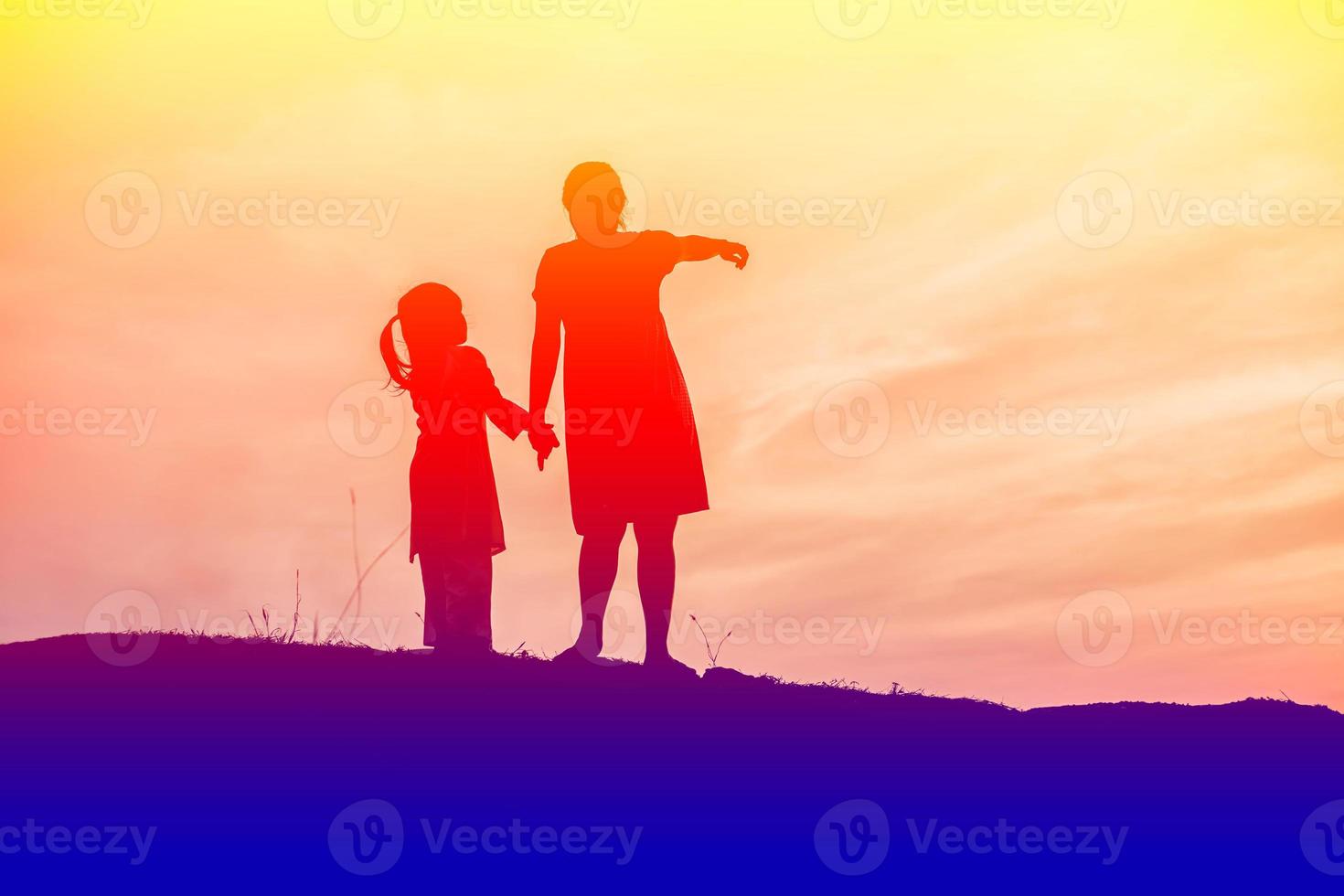 Mother encouraged her son outdoors at sunset, silhouette concept photo