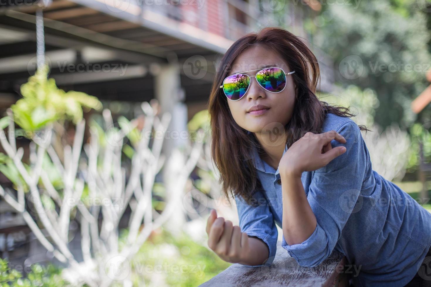 Portrait of young hipster woman relaxing on a balcony on a sunny summer. Smiling enjoy with nature. photo