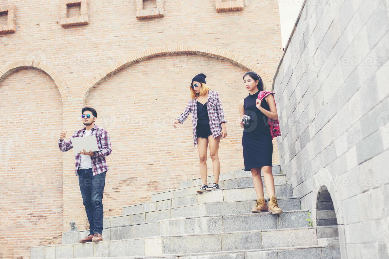 Summer holidays and hipster teenagers group traveling together in urban town having fun and happy time together. photo