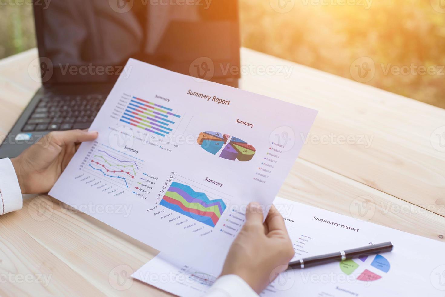 Hands of Businessman working on Laptop Computer with Data Charts photo