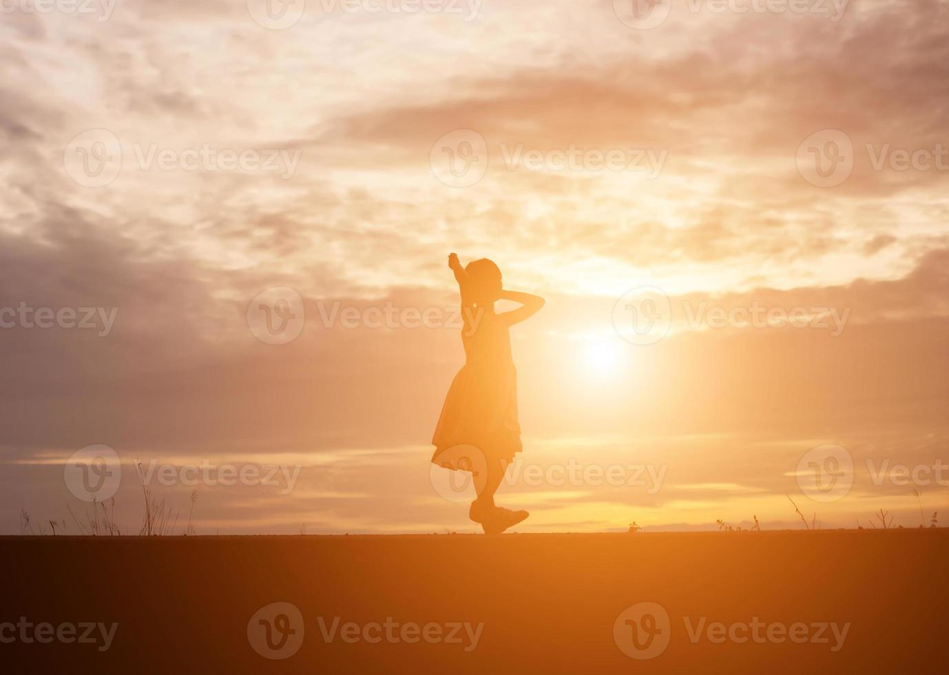 a silhouette of a happy young girl child the arms of his loving mother for a hug, in front of the sunset in the sky on a summer day. photo