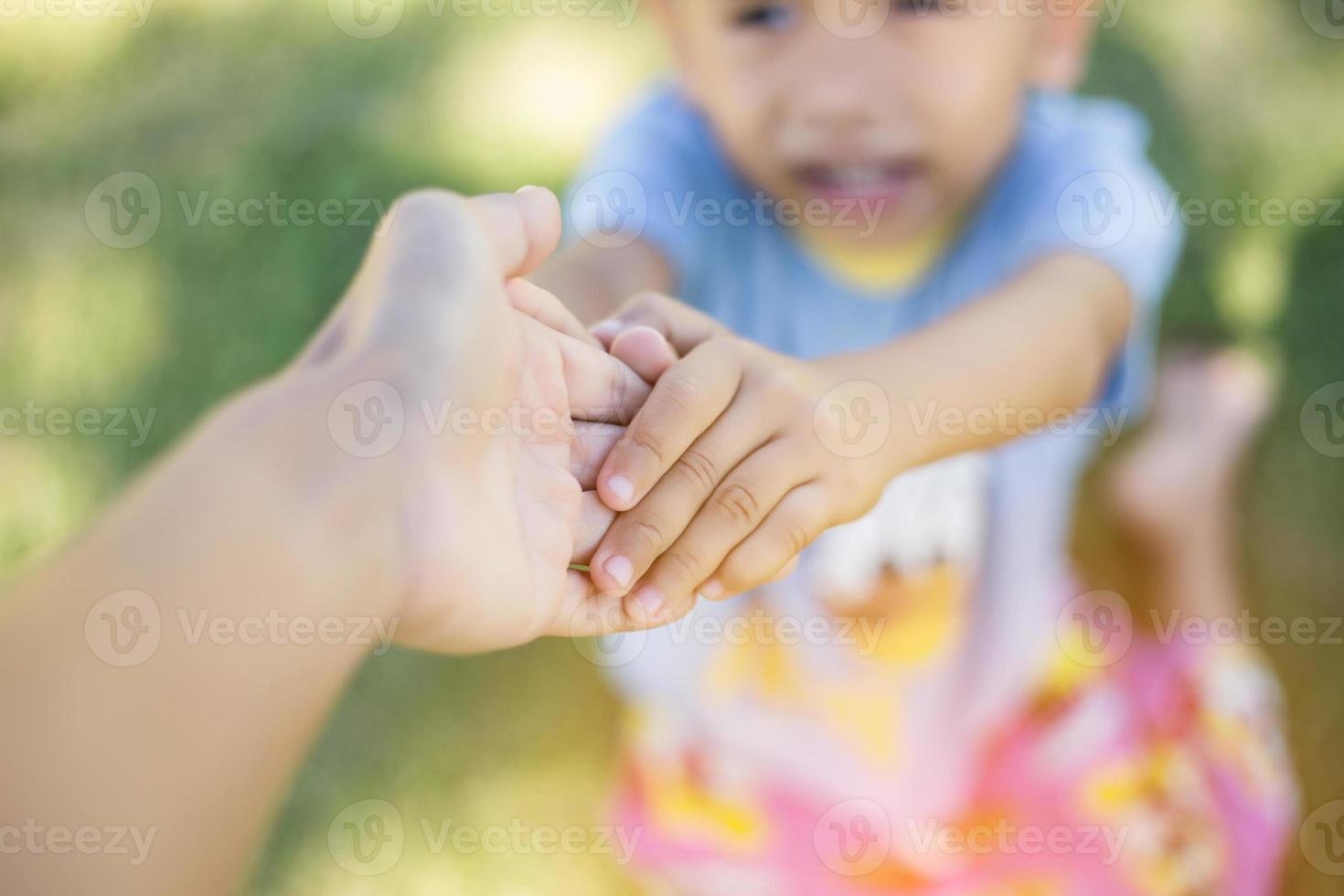 Happy boy child is smiling enjoying adopted life. Portrait of young boy in nature, park or outdoors. Concept of happy family or successful adoption or parenting. photo