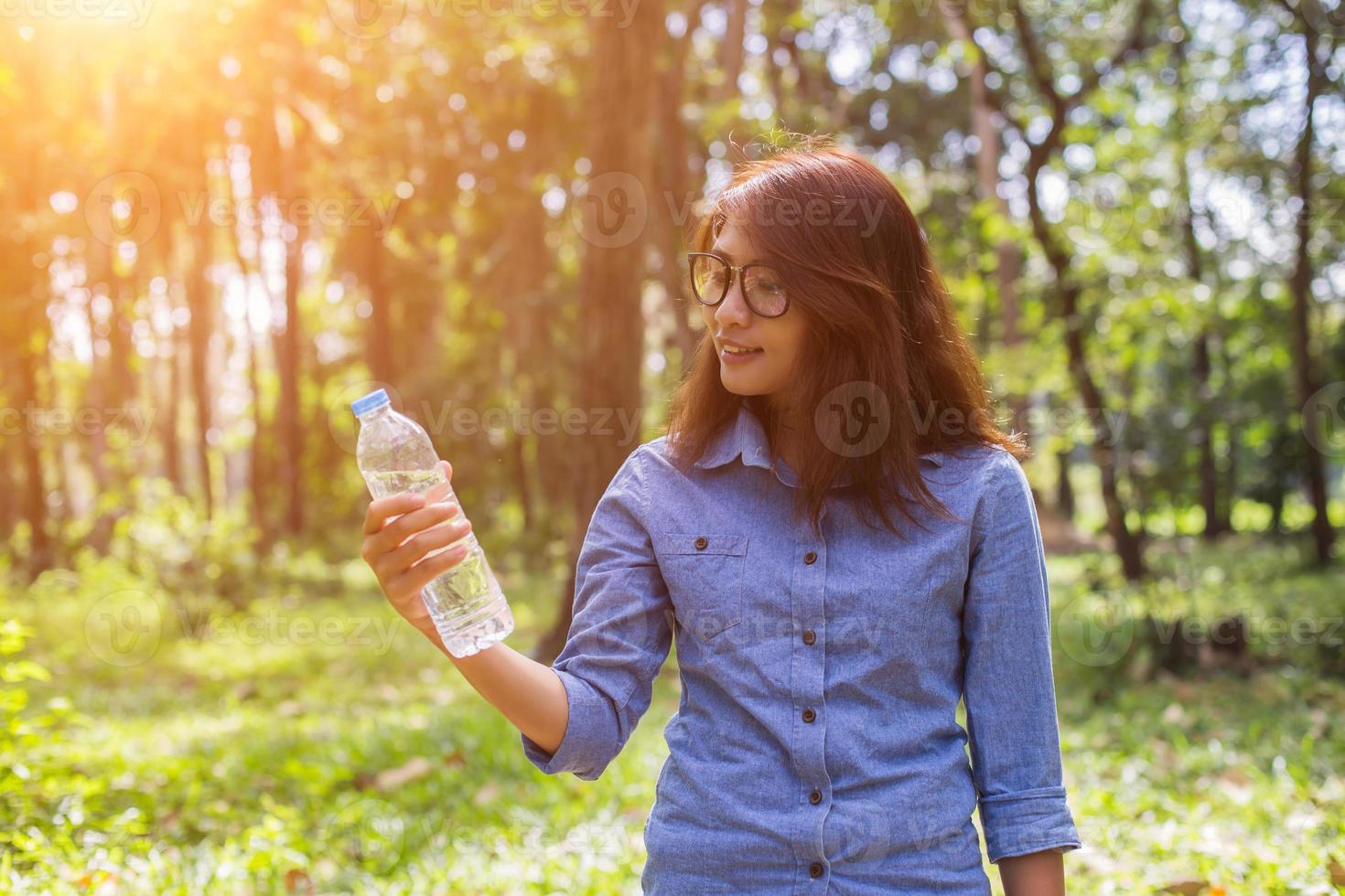 Beautiful young woman drinking water in the morning after finished jogging photo