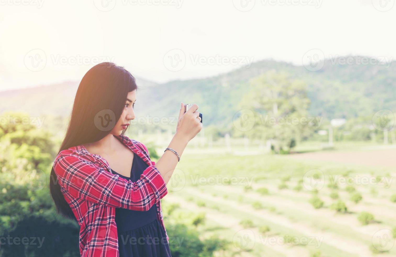 vintage de fotografía de mujeres hermosas mano de pie sosteniendo cámara retro con amanecer, estilo suave de ensueño foto