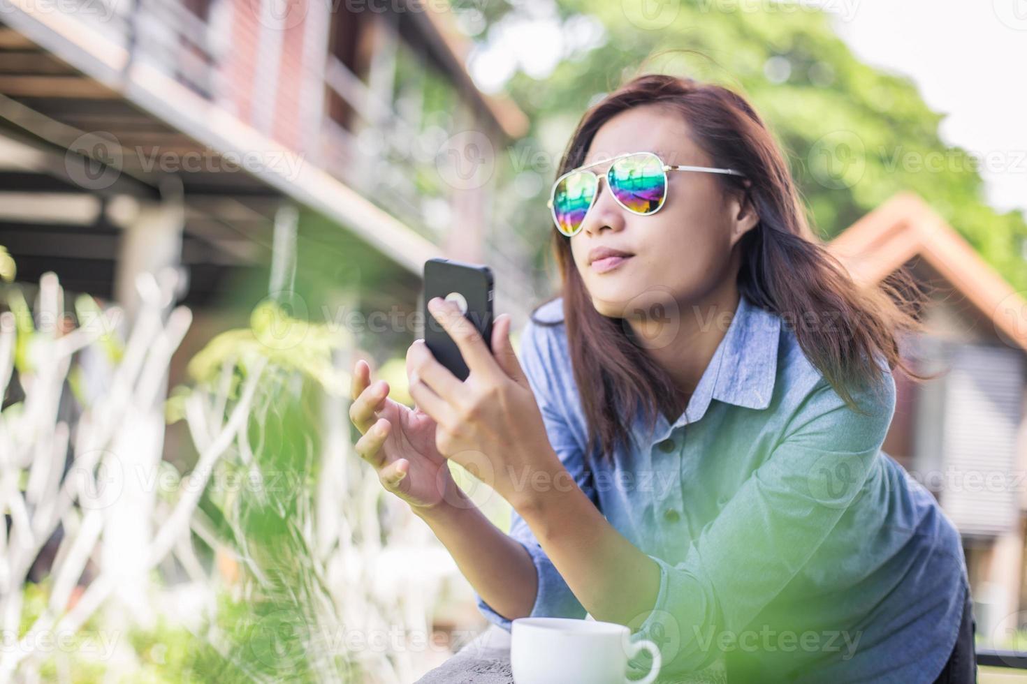 Portrait of young hipster woman relaxing on a balcony on a sunny summer. Smiling enjoy with nature. photo