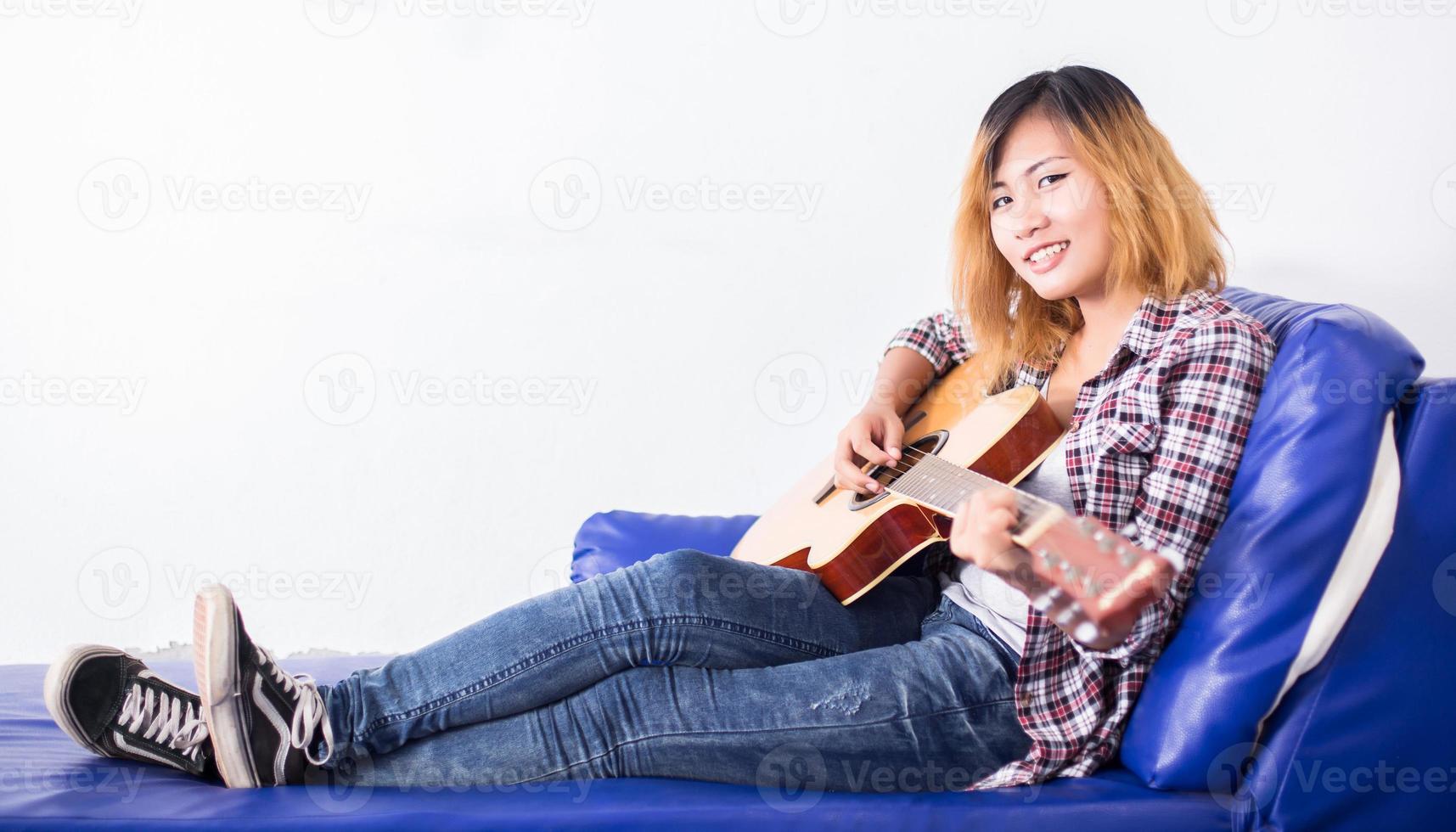 mujer joven inconformista tocando una guitarra. foto