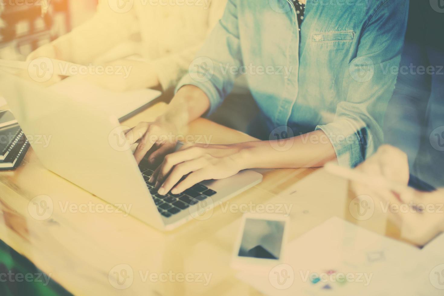 Business team working on laptop, while sitting at office. Business people. photo