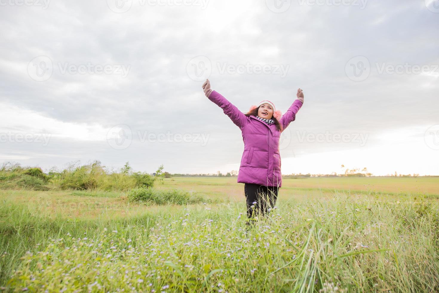 Young woman was playing in a field of flowers in the winter air. photo