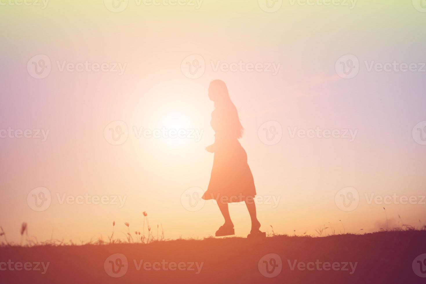 silhouette of a young woman standing alone photo