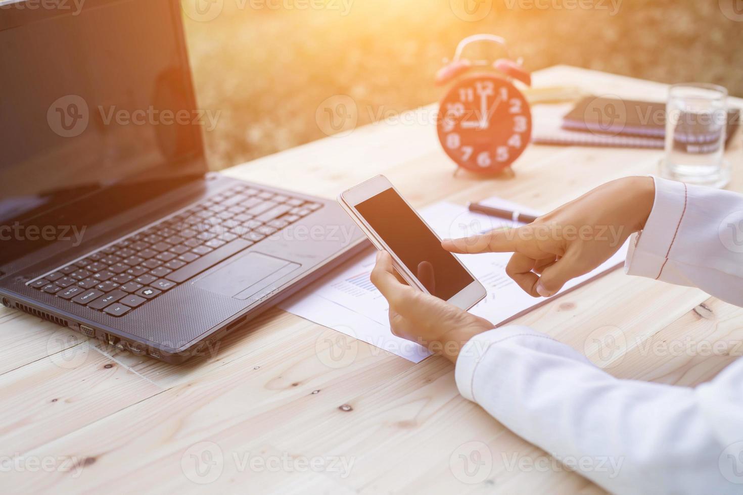 Hands of Businessman working on Laptop Computer with Data Charts photo