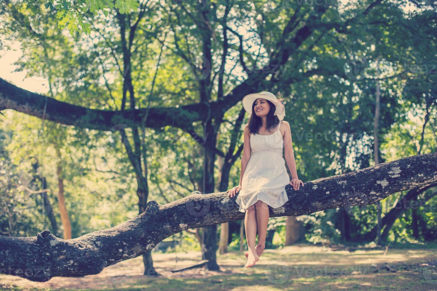 Young teen girl sitting on tree photo