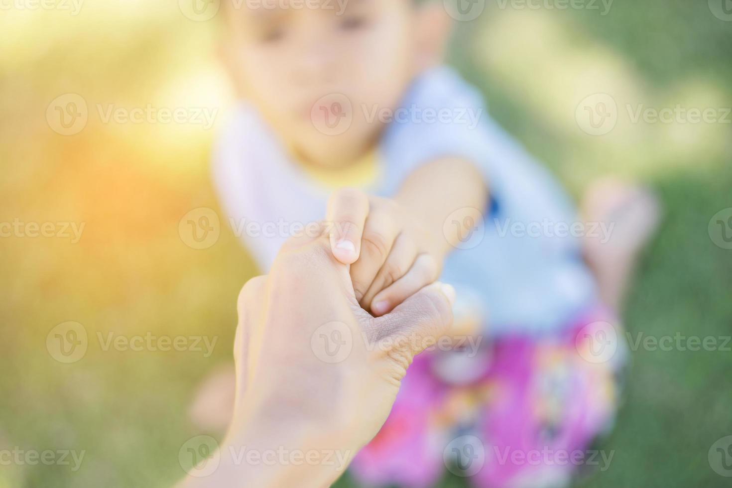 Happy boy child is smiling enjoying adopted life. Portrait of young boy in nature, park or outdoors. Concept of happy family or successful adoption or parenting. photo