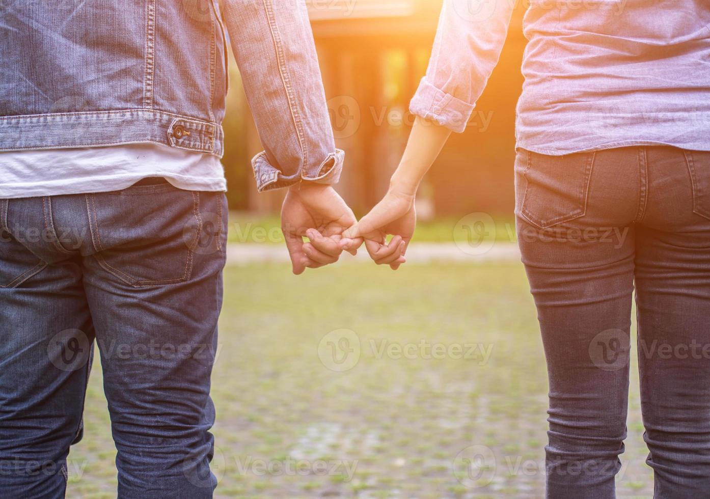 A young couple holding hands. In Nature sunrise photo