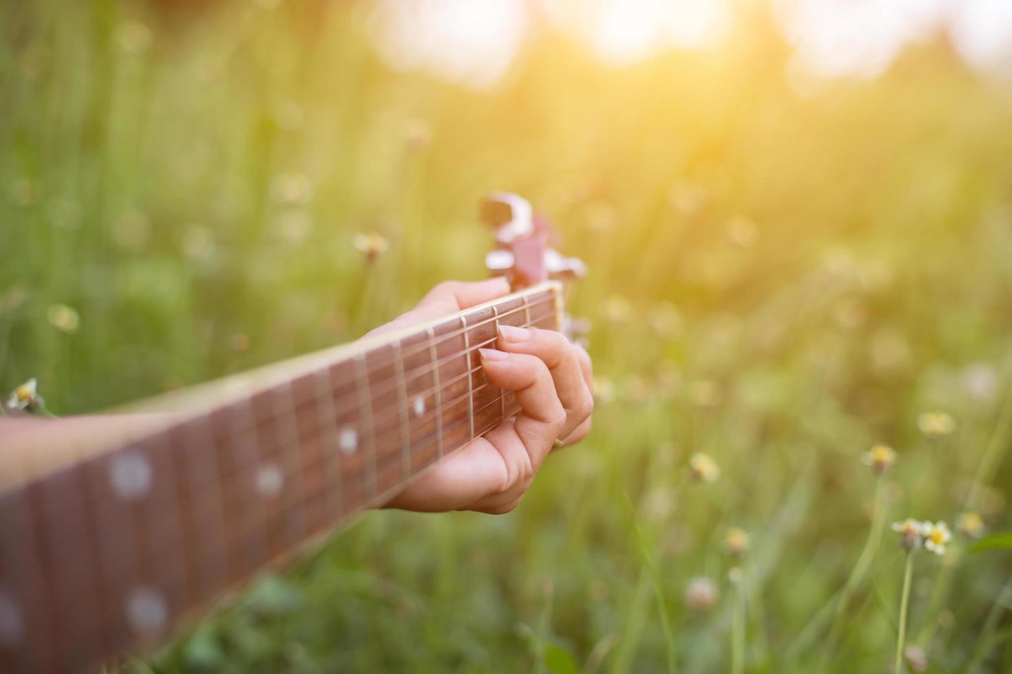 Young hipster woman playing guitar to relaxing on his holiday, enjoy with natural and fresh air. photo