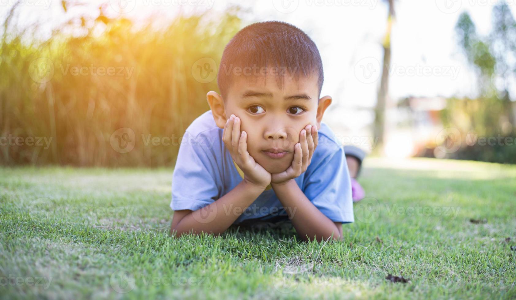 Happy boy child is smiling enjoying adopted life. Portrait of young boy in nature, park or outdoors. Concept of happy family or successful adoption or parenting. photo