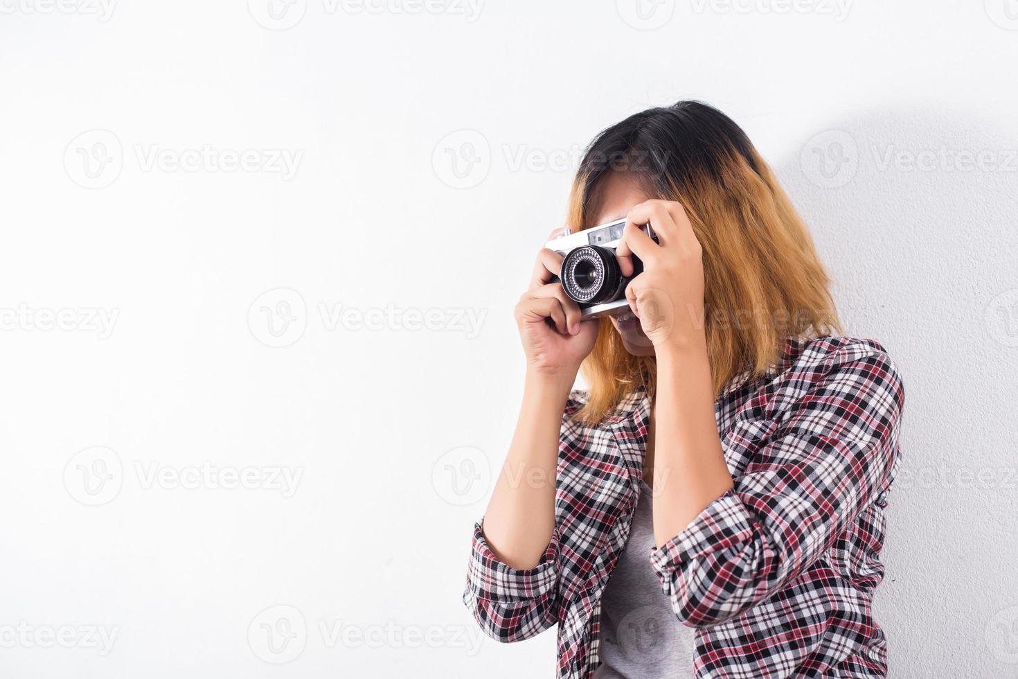 mujer joven hermosa hipster con una vieja cámara retro. foto