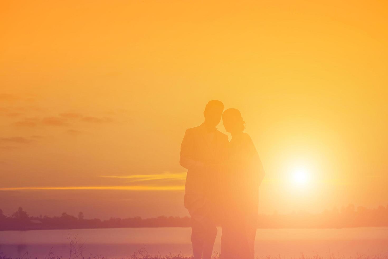silhouette of two girls facing each other hold hands together photo