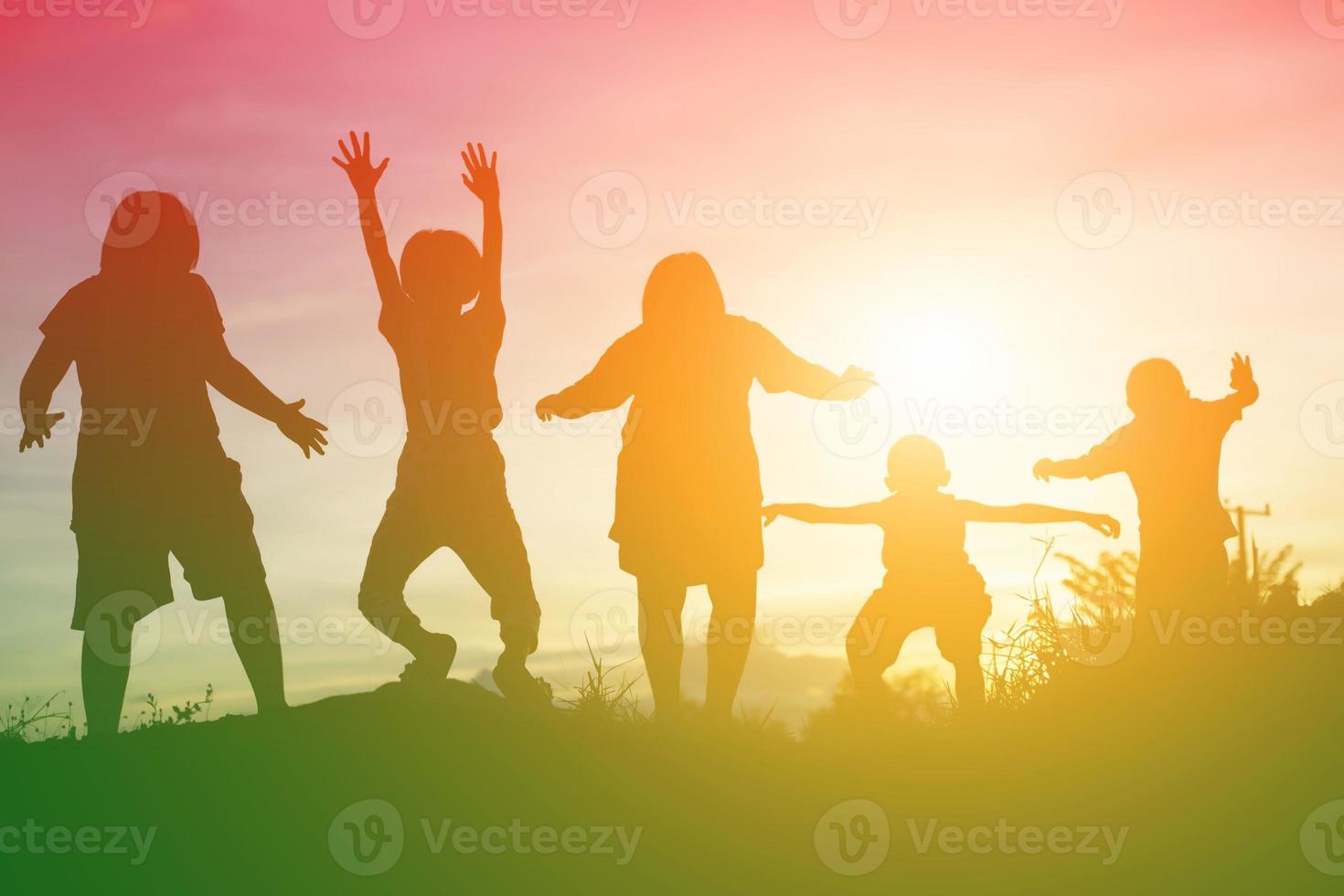 silueta de niños felices y puesta de sol feliz foto