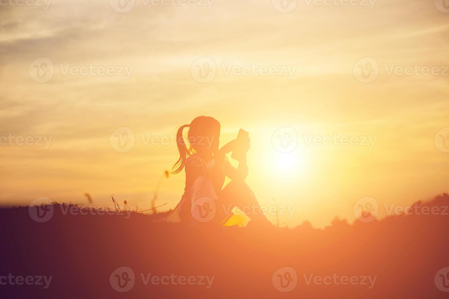 Girl at the beach texting on sunset photo