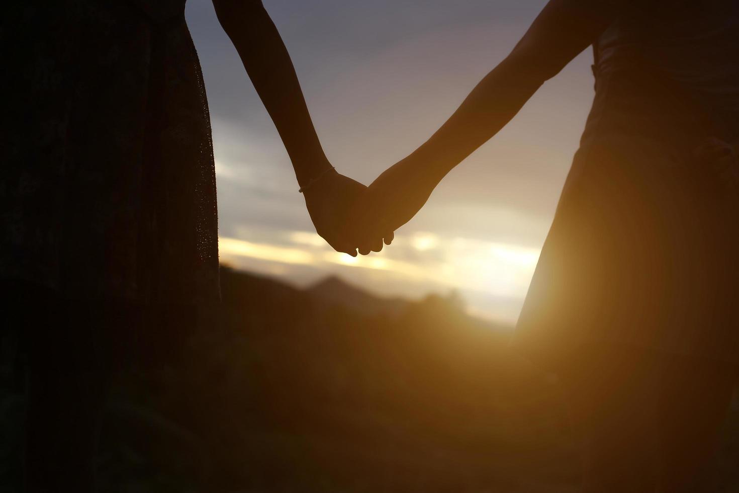 young couple holding hands. In Nature sunrise photo