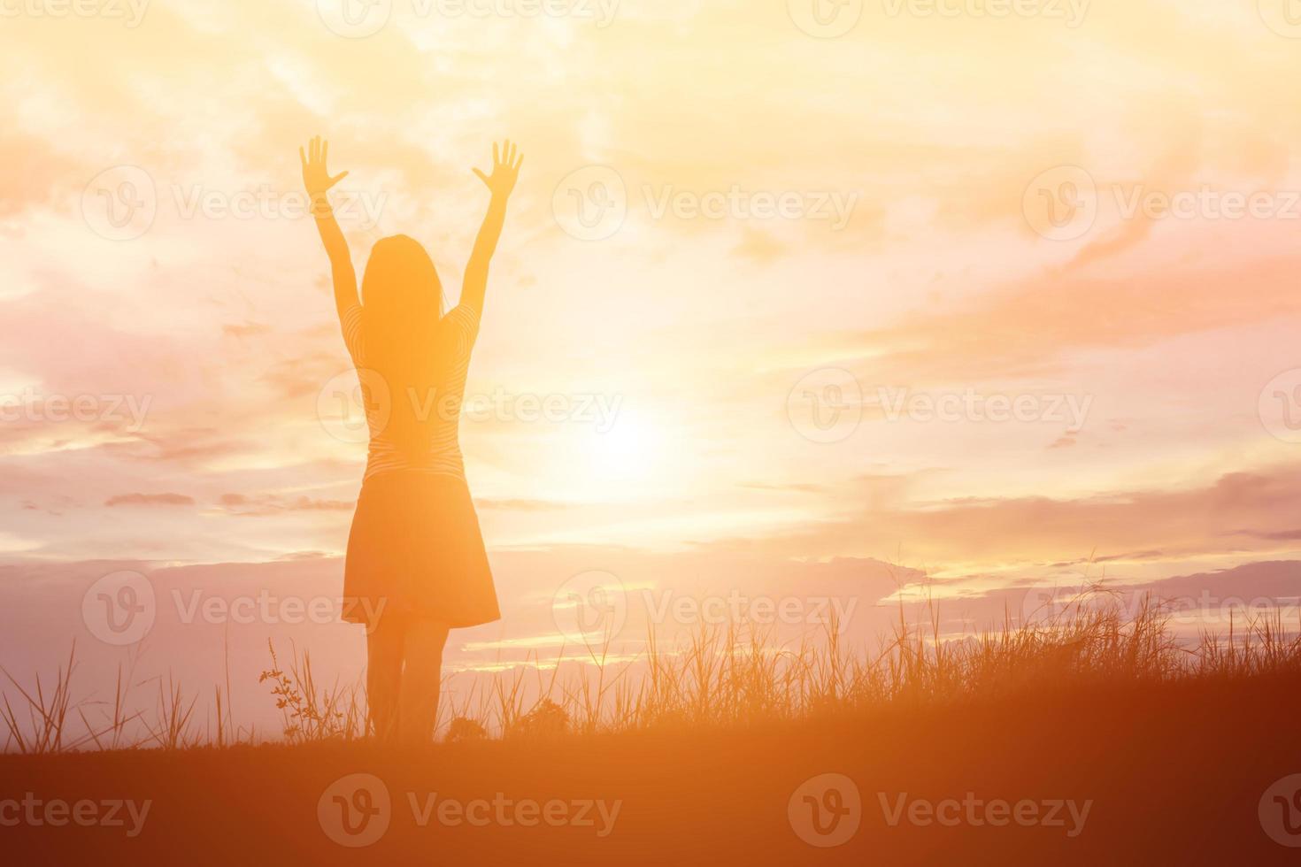 Silhouette of woman praying over beautiful sky background photo