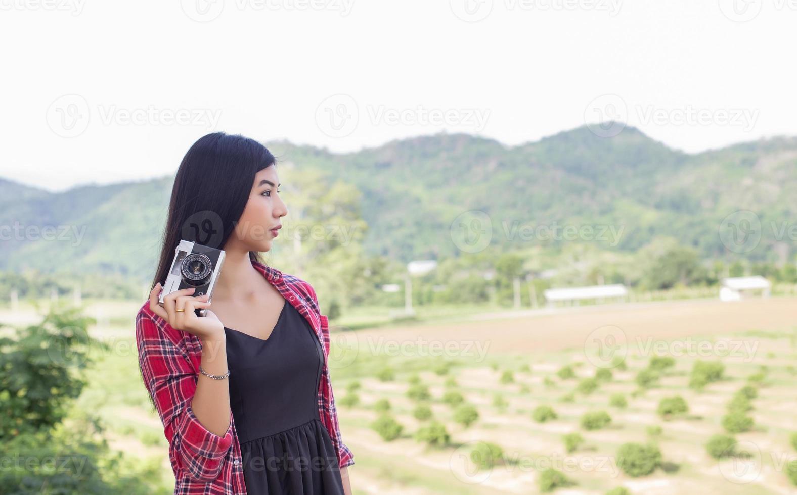 Vintage of beautiful women photography standing hand holding retro camera with sunrise,dream soft style photo