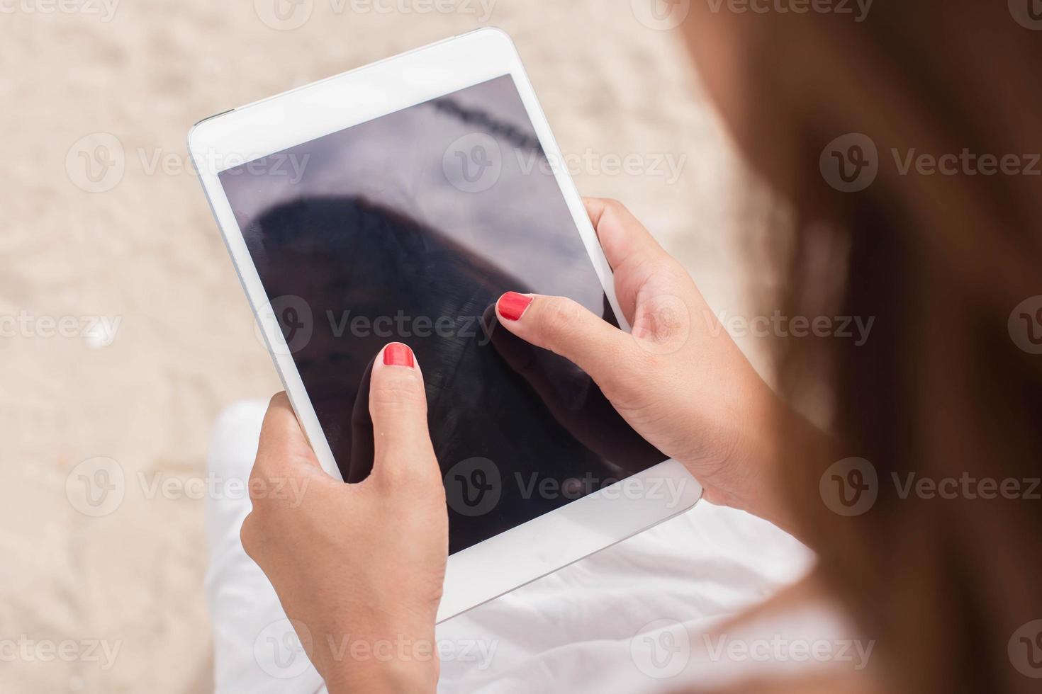 Young female sitting at cafe table with digital tablet photo
