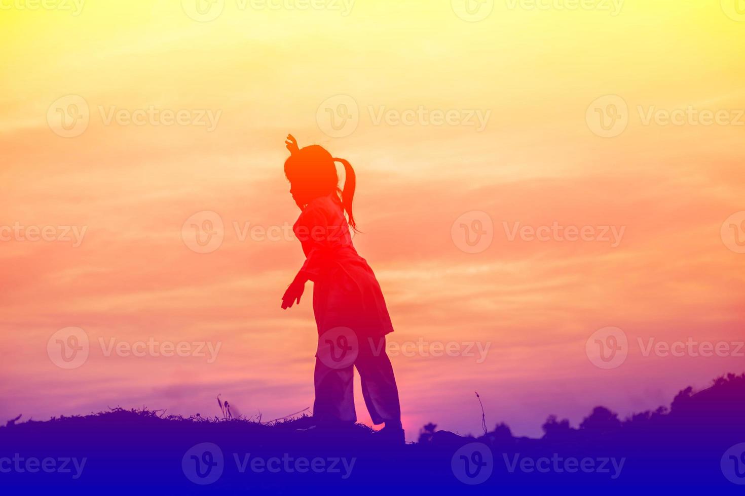 silueta de niño, momentos de alegría del niño. en la puesta de sol de la naturaleza foto